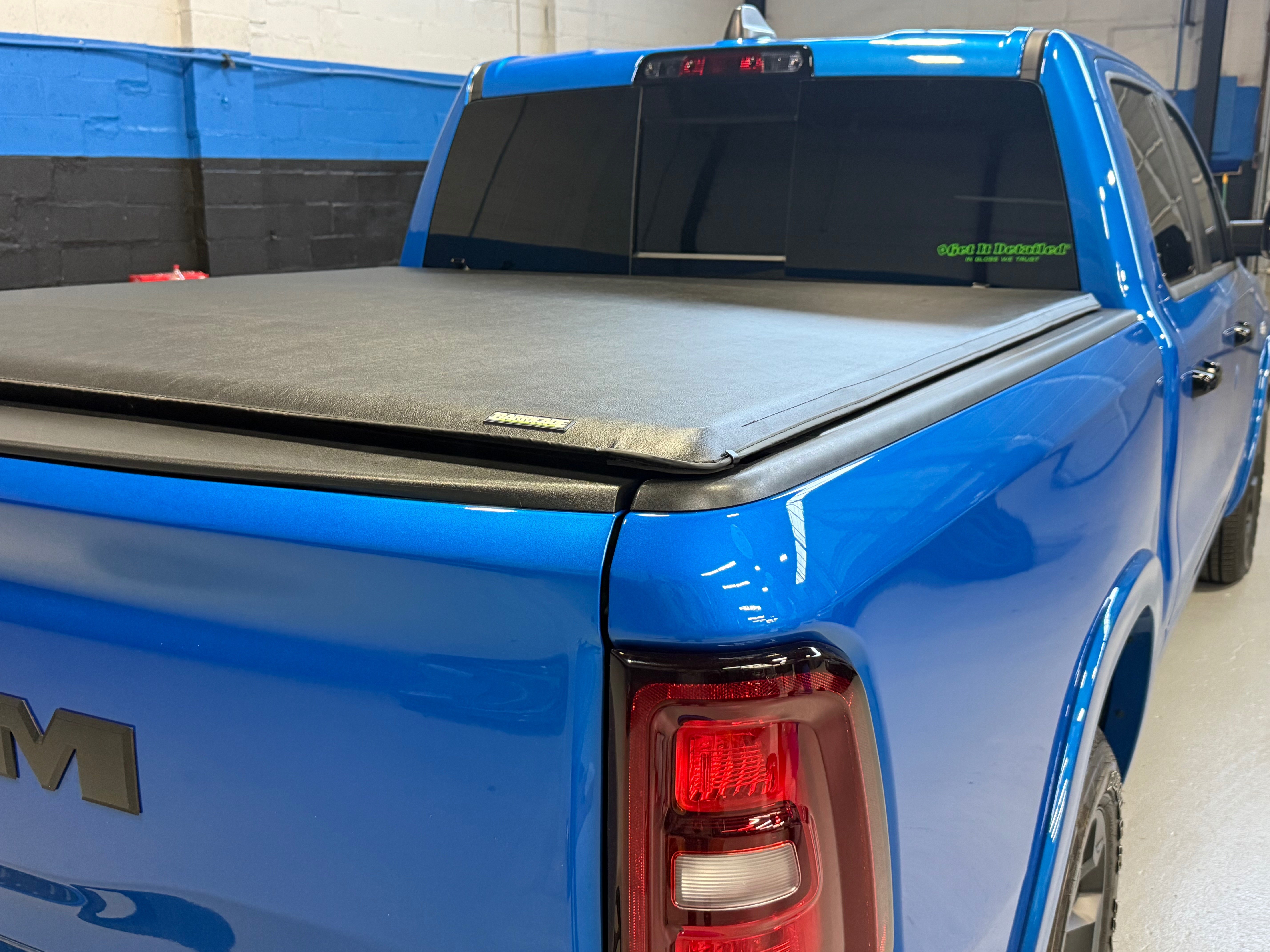 Blue Ram pickup a soft roll-up tonneau cover closed over the truck bed, providing weather protection and a low-profile appearance.