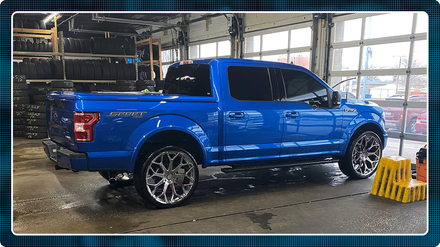 Image of Ford F-150 Sport in a garage to introduce cost of lift kit installation section comparing DIY and mechanic installs