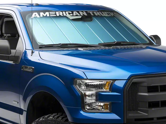 Blue Ford F-150 with a reflective windshield sunshade installed, helping block sunlight and reduce interior temperatures while parked.
