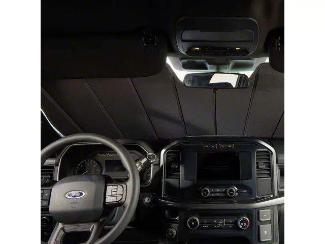 Interior view of a pickup truck with an insulated windshield sunshade installed, showing the thermal barrier that helps reduce cabin heat and protect interior surfaces.