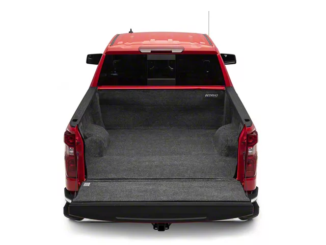 Red Chevrolet Silverado with a BedRug truck bed liner installed, featuring a carpet-like cushioned surface that covers the bed floor and walls for cargo protection.