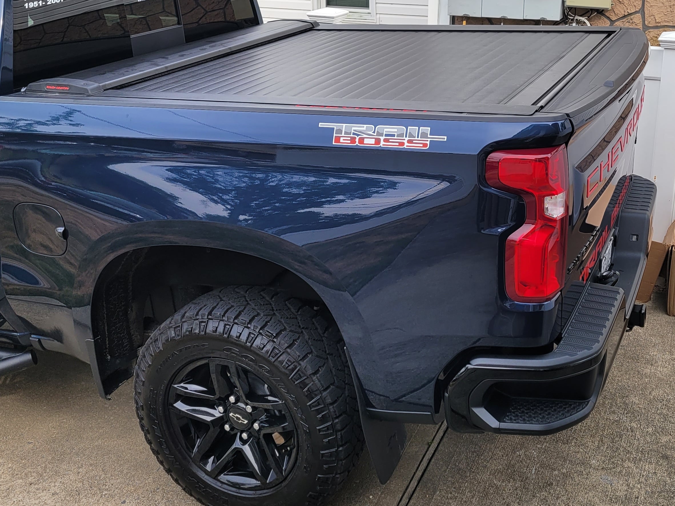 Retractable tonneau cover sliding into canister on a pickup truck bed